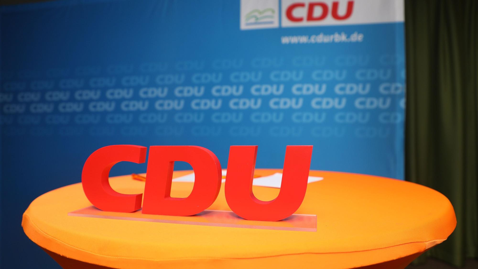 Ein CDU-Schriftzug steht vor eine Wan mit dem Schriftzug CDU RBK.