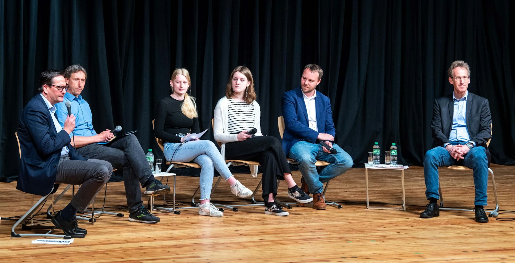 Das Bild zeigt die Diskussionsrunde auf der Bühne des Stadttheaters.