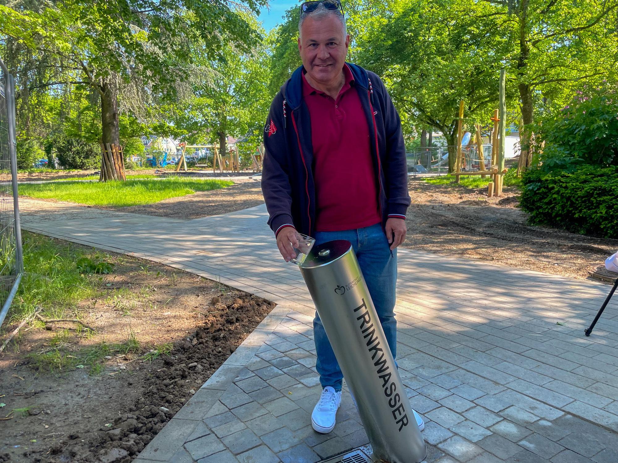In etwa eineinhalb Monaten wird der Neue Stadtpark eröffnet. Bürgermeister Frank Steffes testet den neuen Trinkwasserbrunnen.