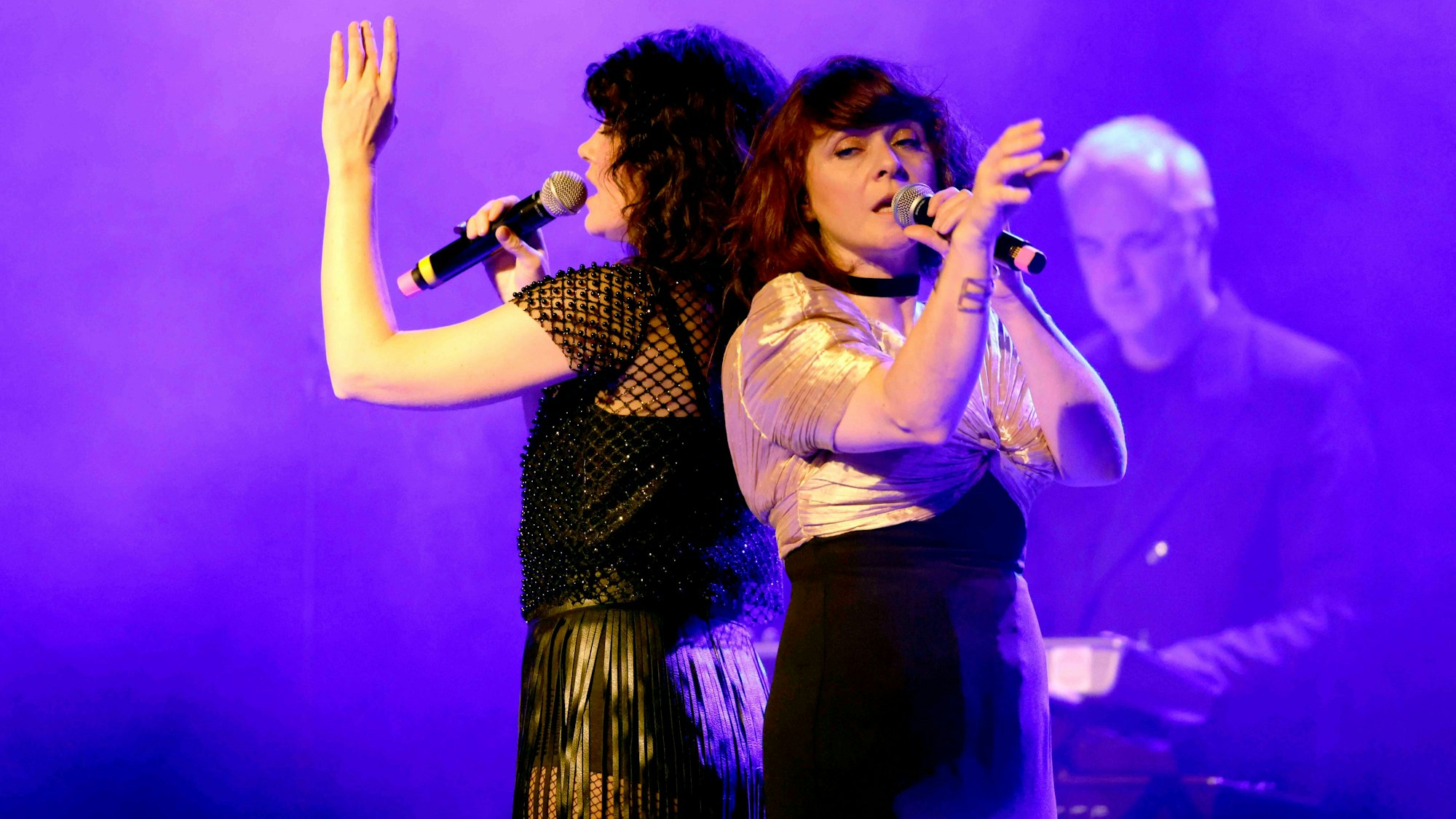 Zwei Frauen singen in Mikrofone.