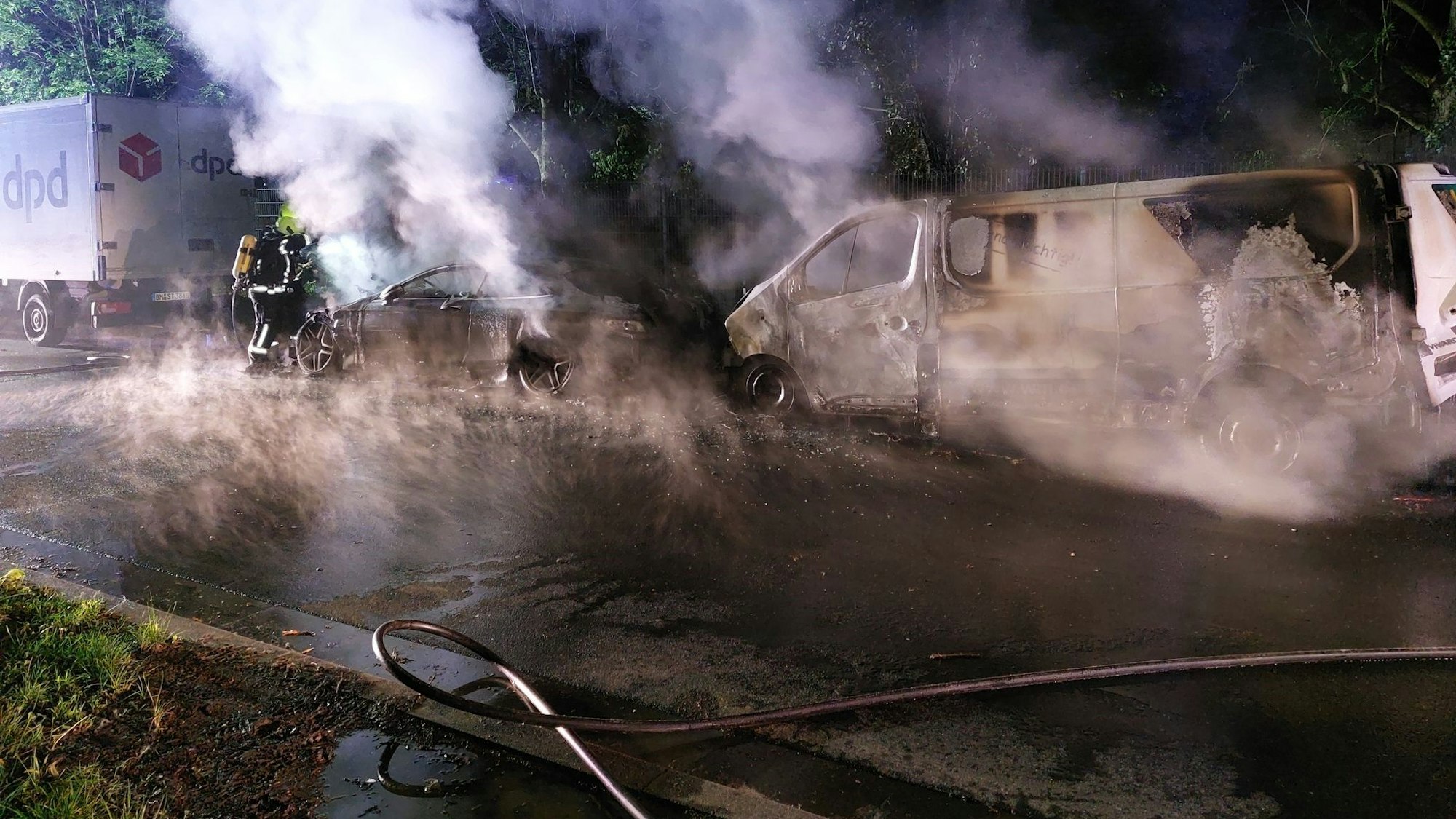 Dicke Rauchschwaden ziehen von zwei gelöschten Fahrzeugen durch die Luft.
