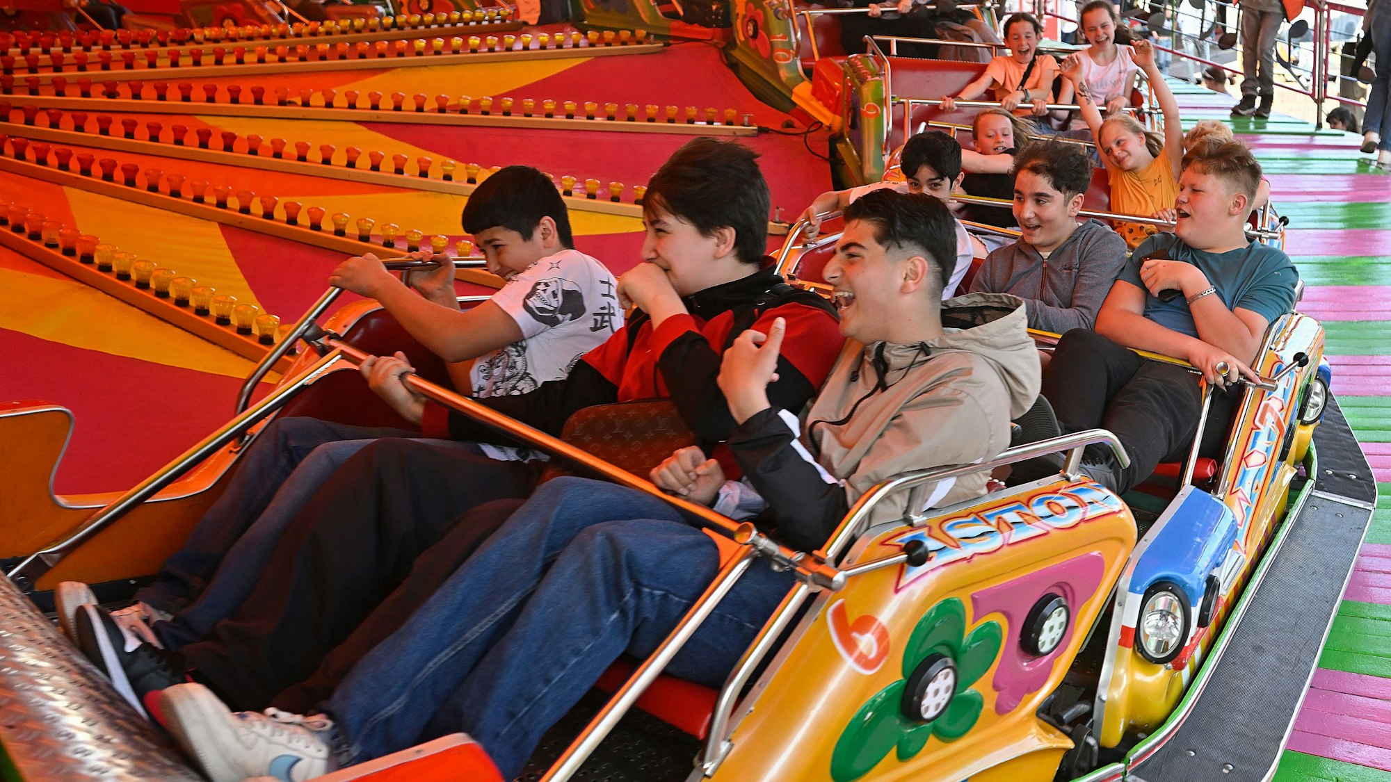 Jugendliche fahren in dem „Musikexpress“ auf der Bergisch Gladbach Pfingstkirmes 2023.