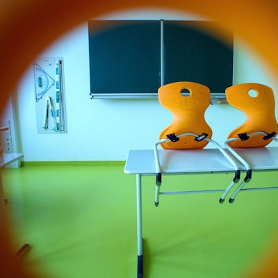 Stühle stehen in einem leeren Klassenzimmer auf einem Tisch. In Würselen bei Aachen hatte die Kleiderwahl eines Lehrers nun Konsequenzen. (Symbolbild)