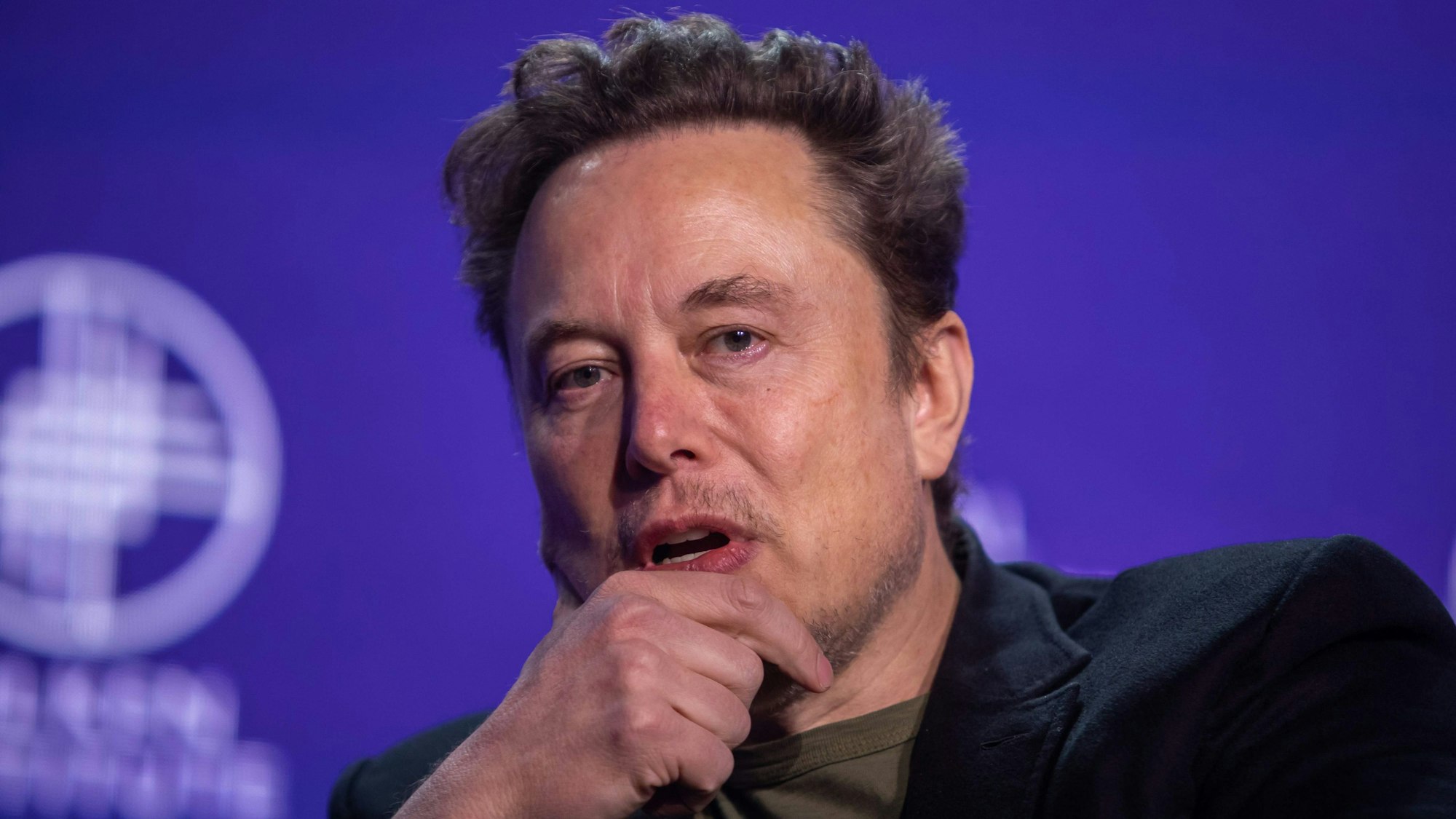Elon Musk schaut nachdenklich im Gespräch.