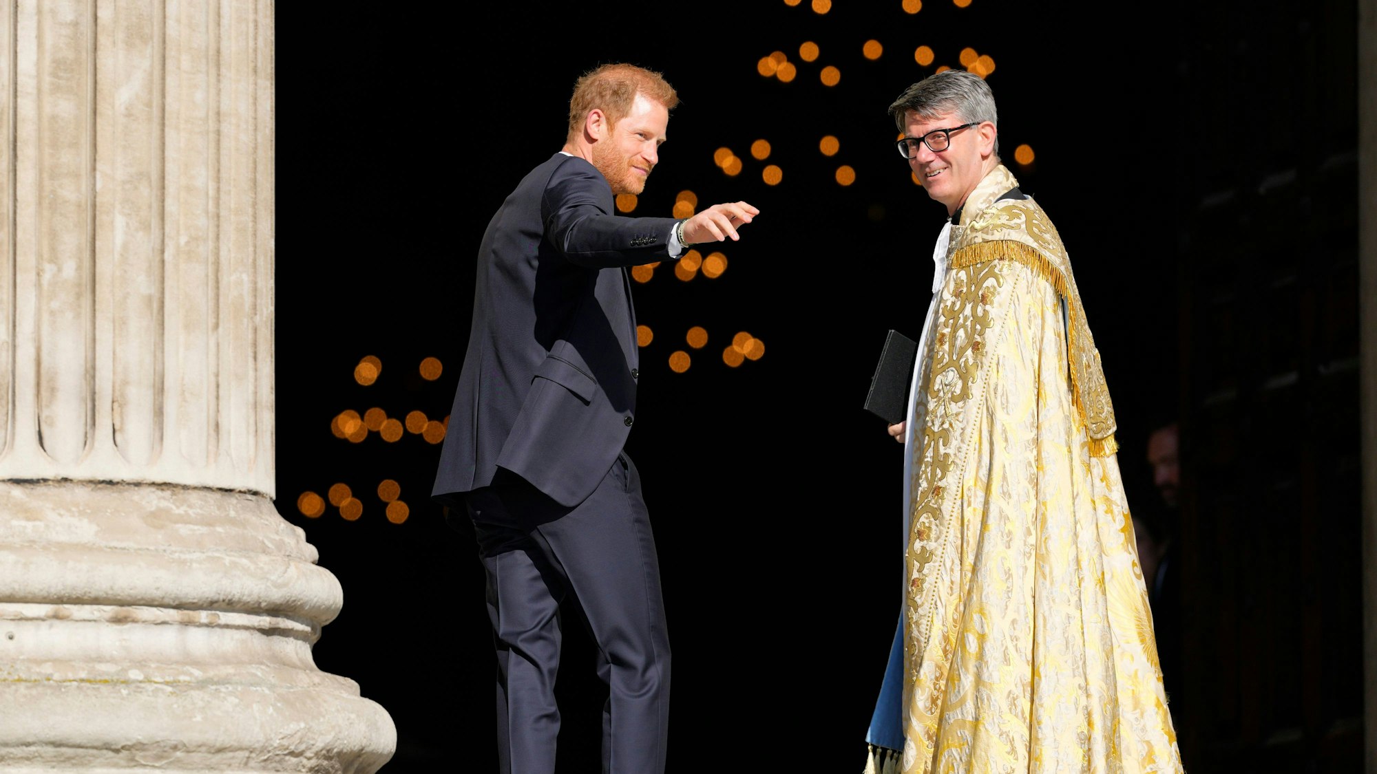 Großbritannien, London: Prinz Harry (l) winkt, während er neben Andrew Tremlett, Dekan der St. Paul's Cathedral, in der St. Paul's Cathedral eintrifft.
