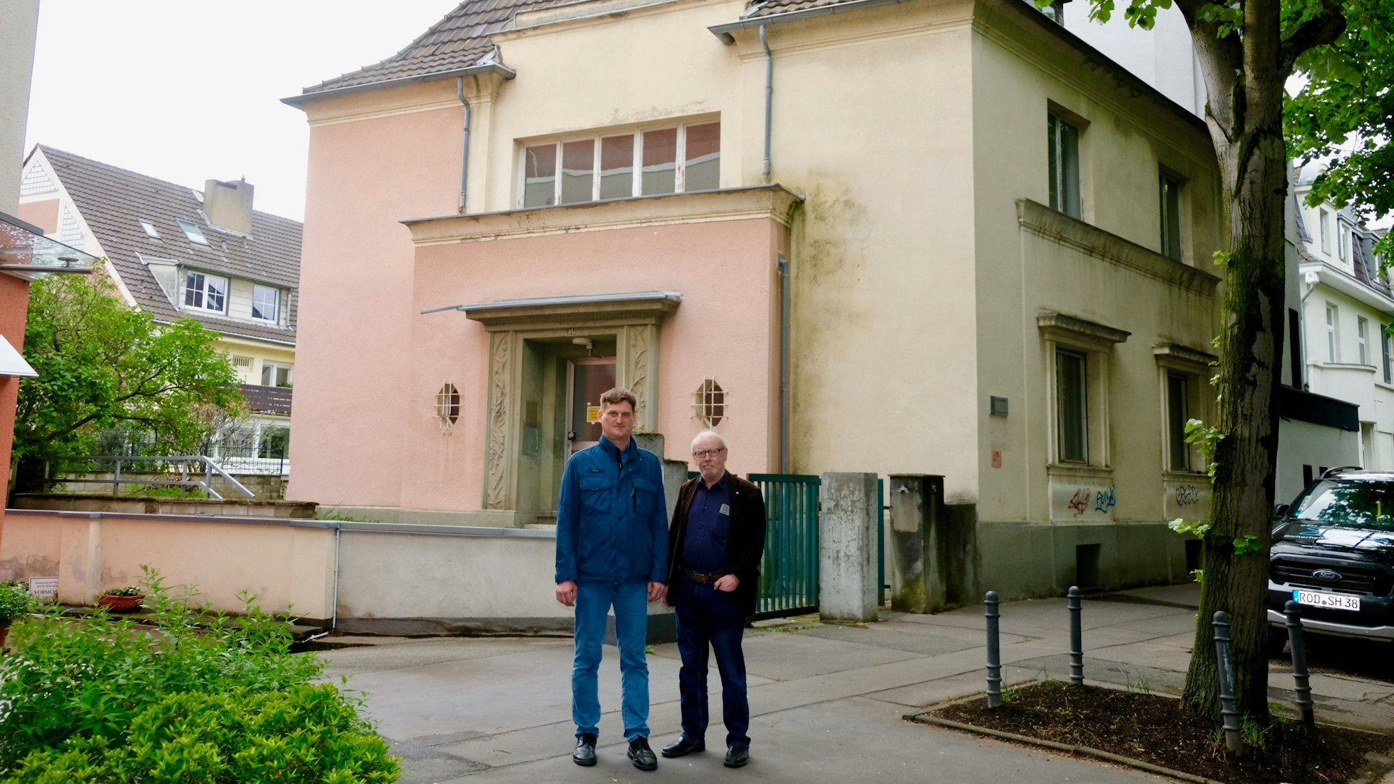 BU: Holger Fiedler (l.) und Friedhelm Hilgers vor dem leerstehenden Wohnhaus der Universität an der Lindenburger Allee 15.