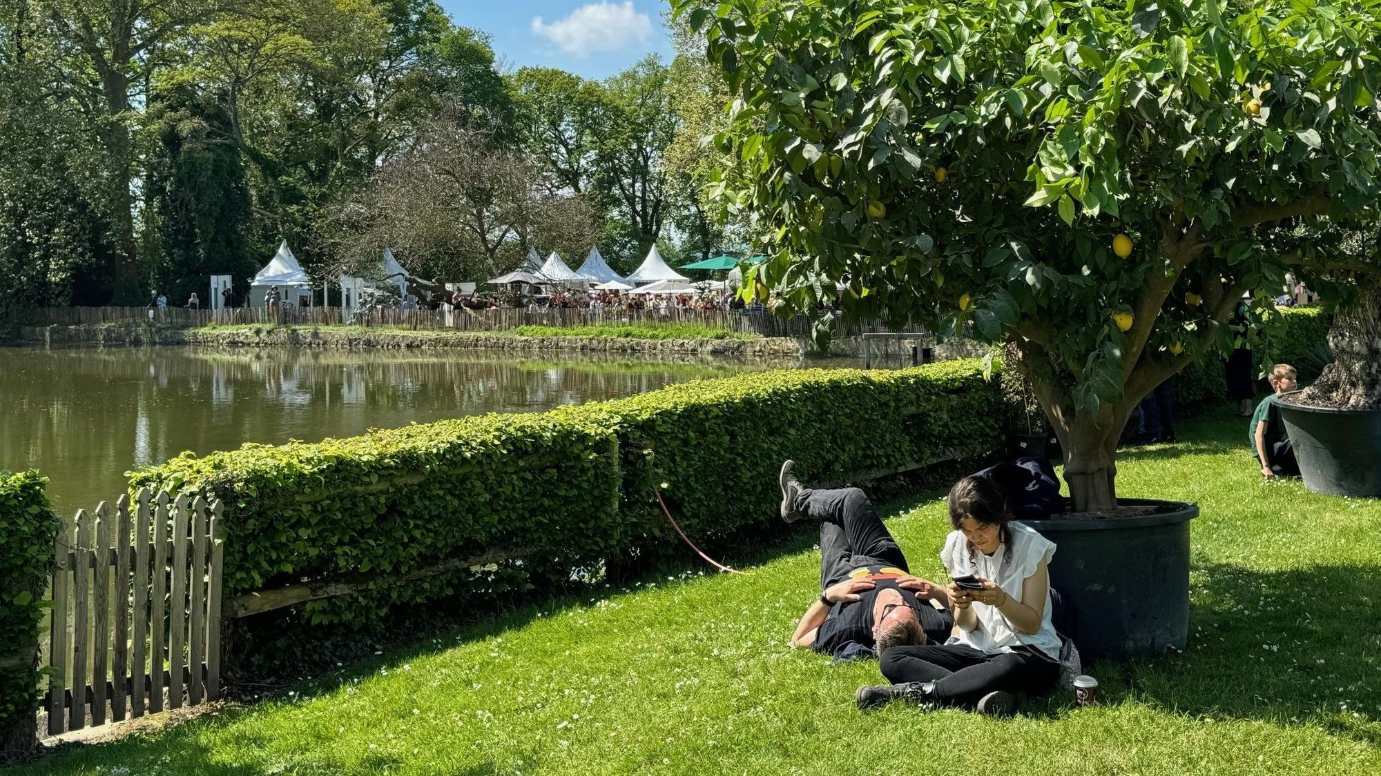Pärchen sitz im Schatten eines Zitronenbaumes am Burggraben