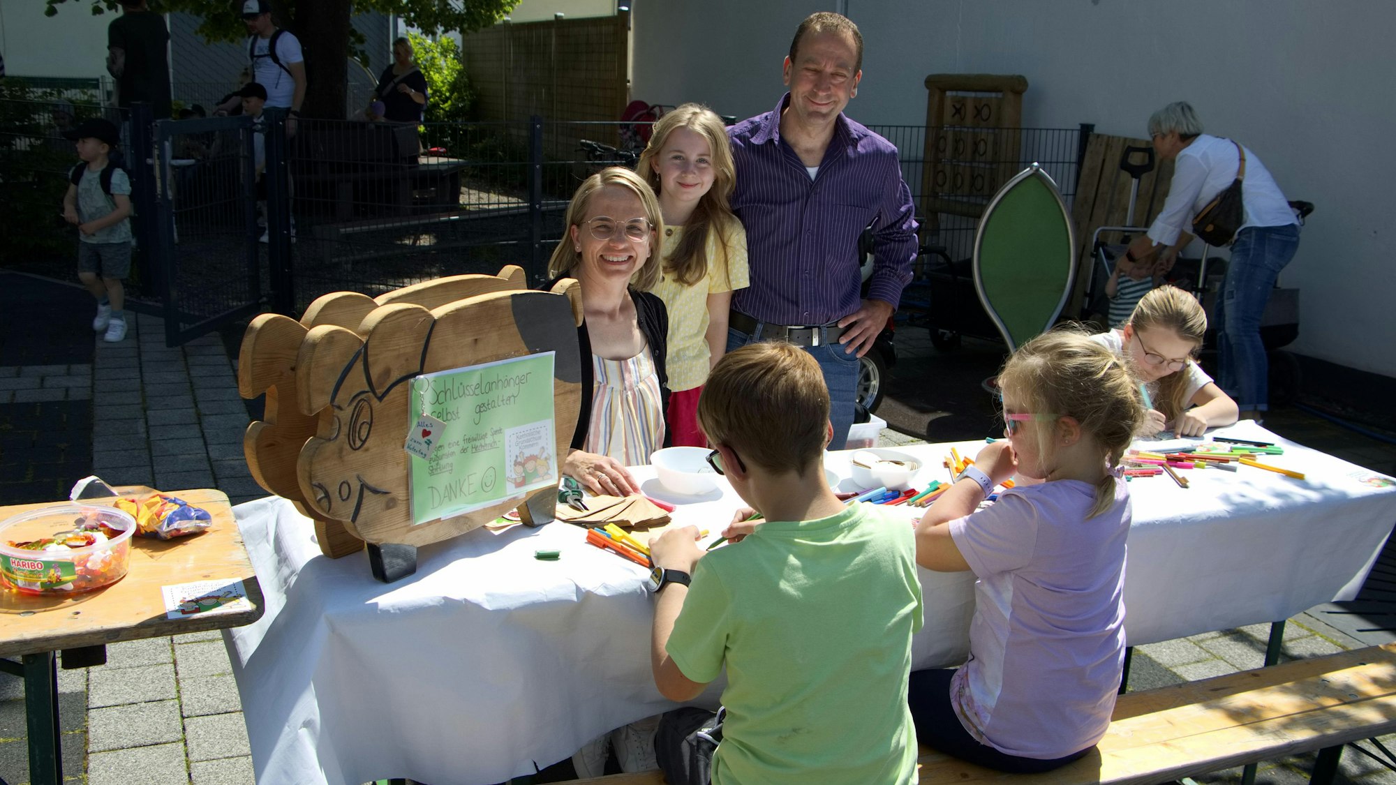 Kinder sitzen an einem Tisch und basteln.