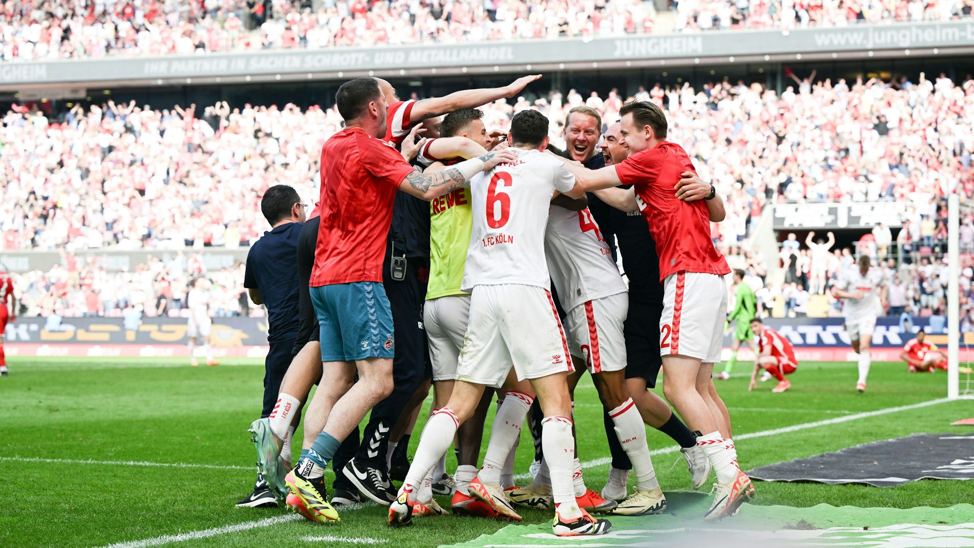 Spieler und Verantwortliche des 1. FC Köln bejubeln in der Nachspielzeit das Siegtor von Damion Downs.