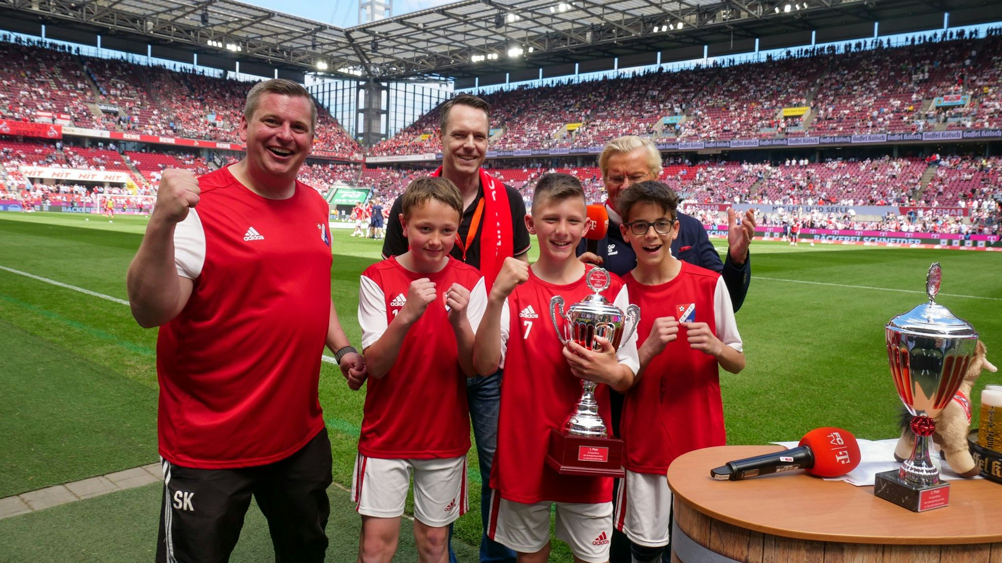 Fußballspieler halten einen Pokal in einem Stadion.