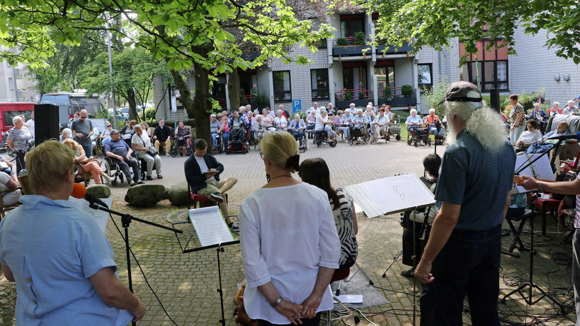 Eine Band spielt, Zuhörer sitzen davor.