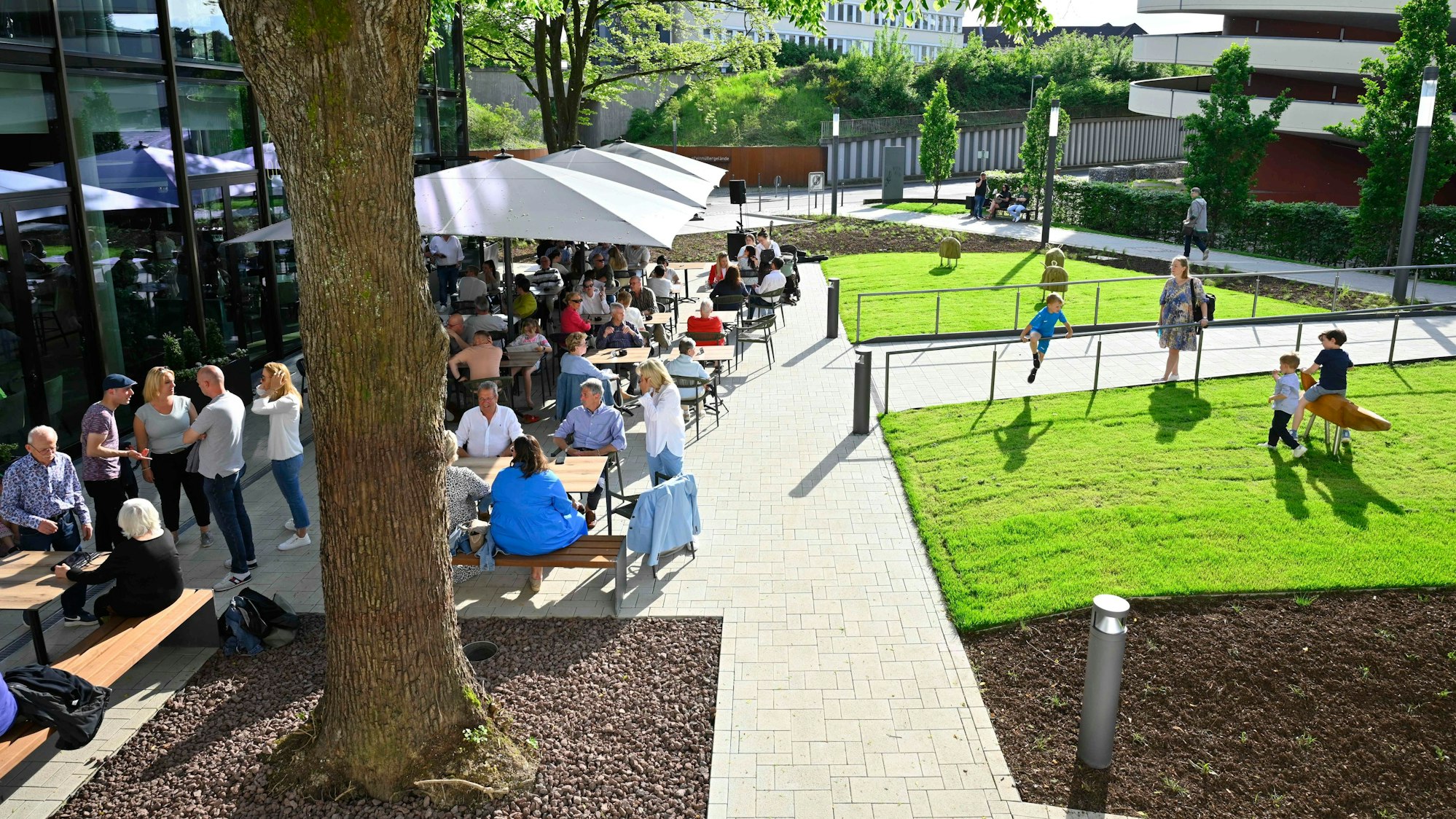 Blick auf Besucher einer Außengastronomie im Sonnenschein