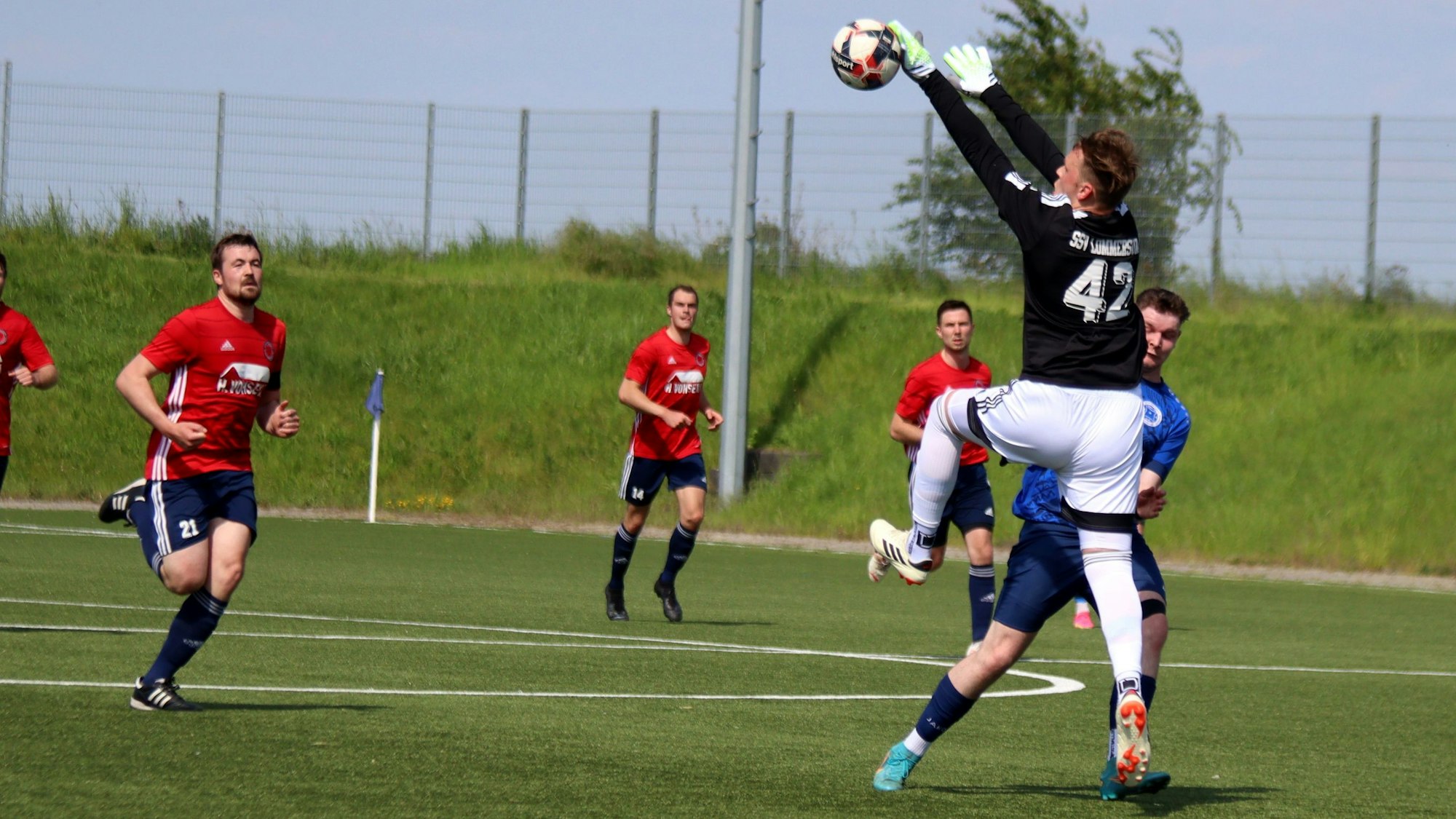 Ein Torwart spielt außerhalb des Strafraums einen Ball mit der Hand.