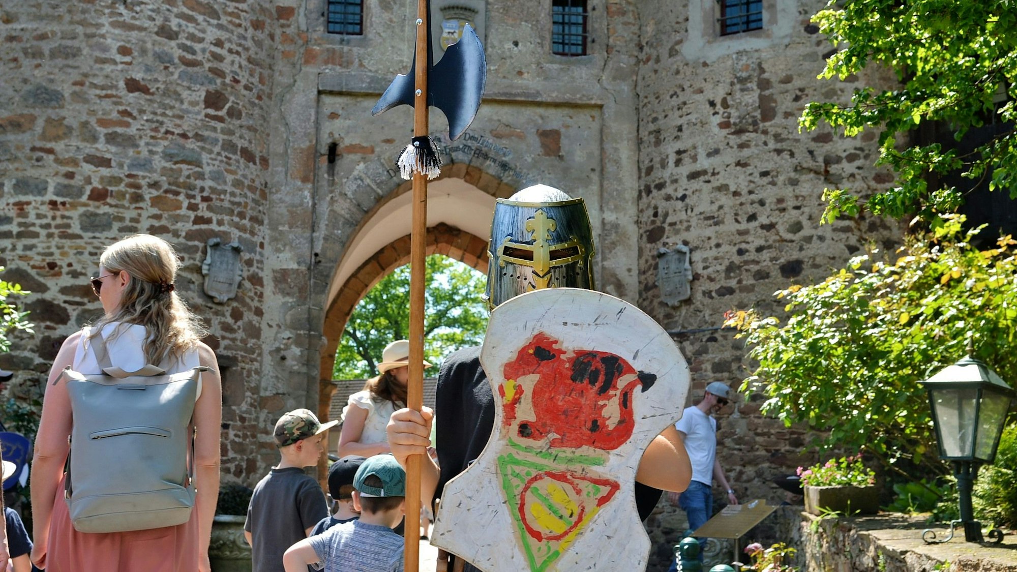 Ein junger Ritter mit Helm, Schild und Hellebarde ist zu sehen.