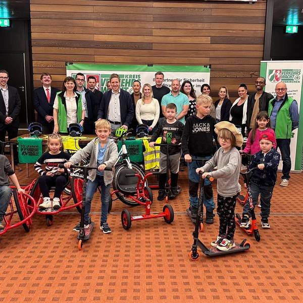 Das Bild zeigt Vertreter aus den Schulen und Kitas sowie der Verkehrswacht und Sponsoren. Zudem sind Kinder zu sehen, die die neuen Spielgeräte testen.