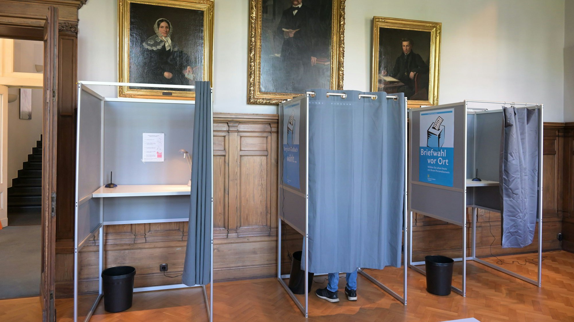 Vor Gemälden der Zanders-Familie stehen Wahlkammern.
