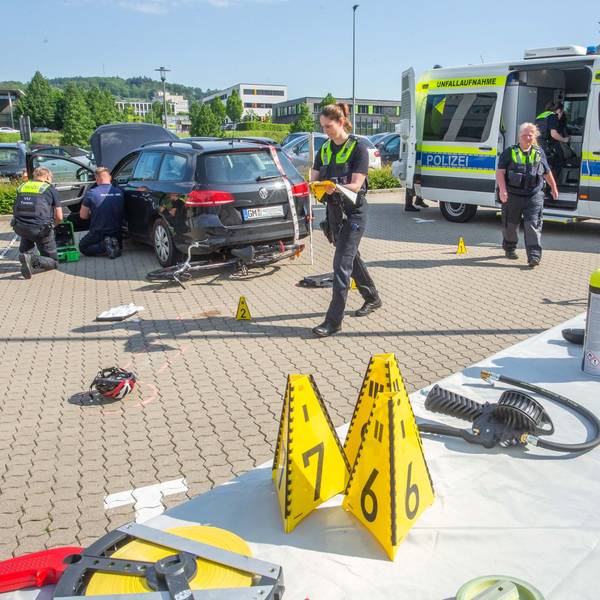 Polizisten arbeiten an einem Auto, das über ein Fahrrad gefahren ist.