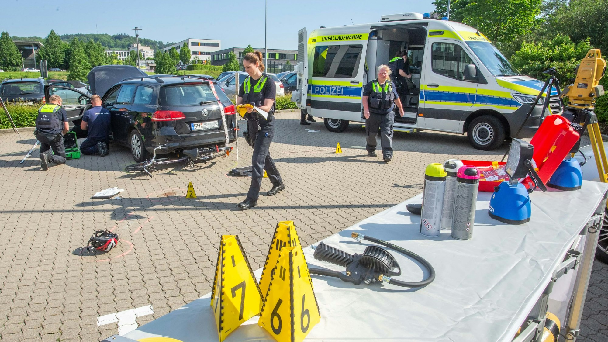 Polizisten arbeiten an einem Auto, das über ein Fahrrad gefahren ist.