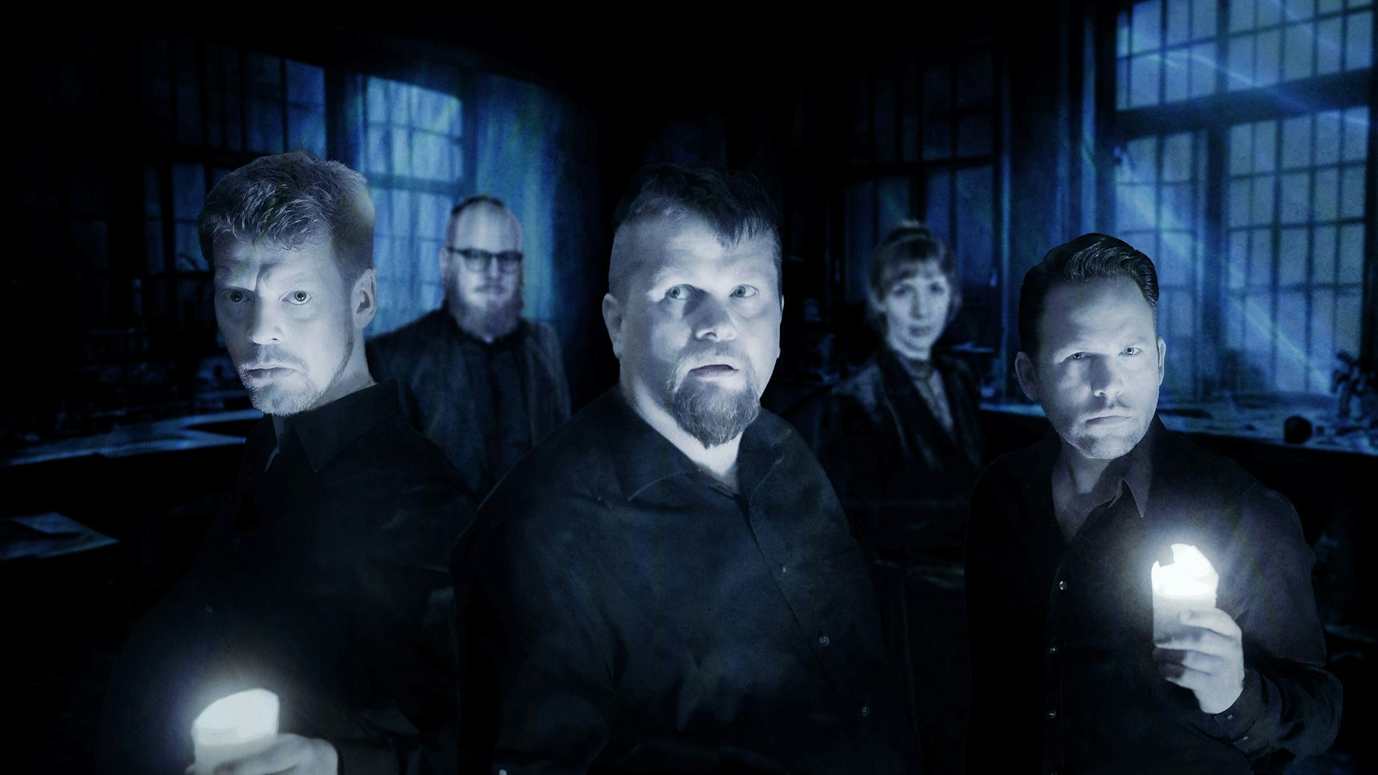 Zu sehen sind Männer mit Lampen in einem dunklen Gebäude.