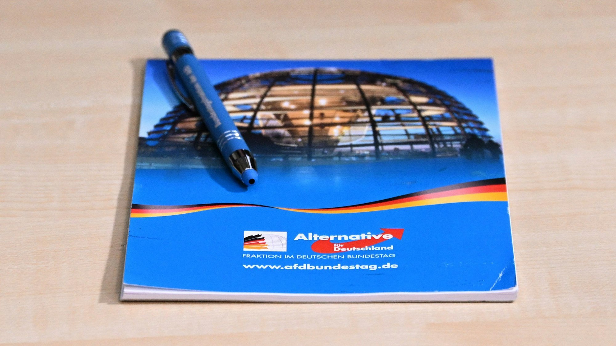 Ein Schreibblock und ein Stift mit den Logos der AfD (Symbolbild)