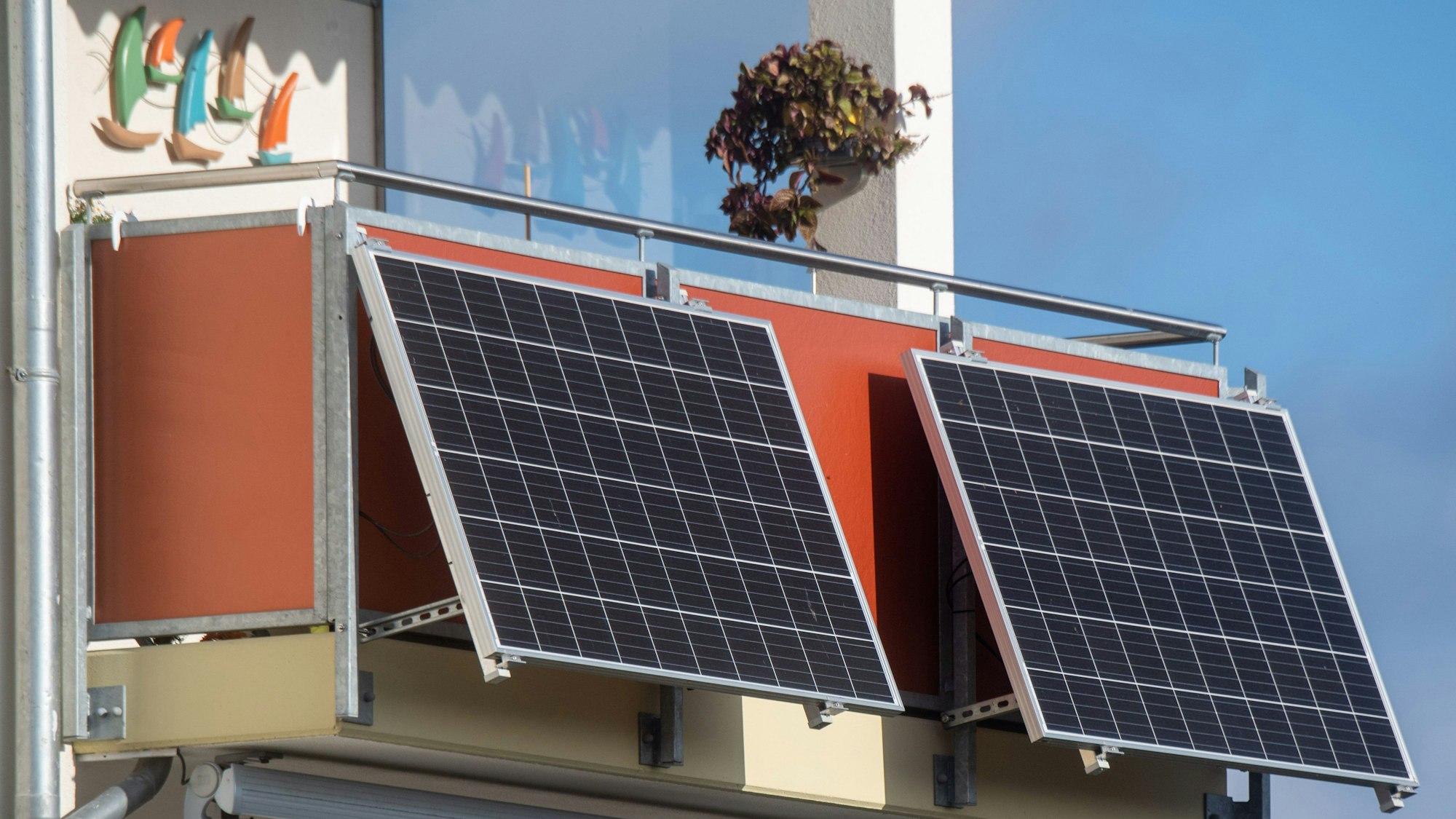 Solarmodule für ein sogenanntes Balkonkraftwerk hängen an einem Balkon.