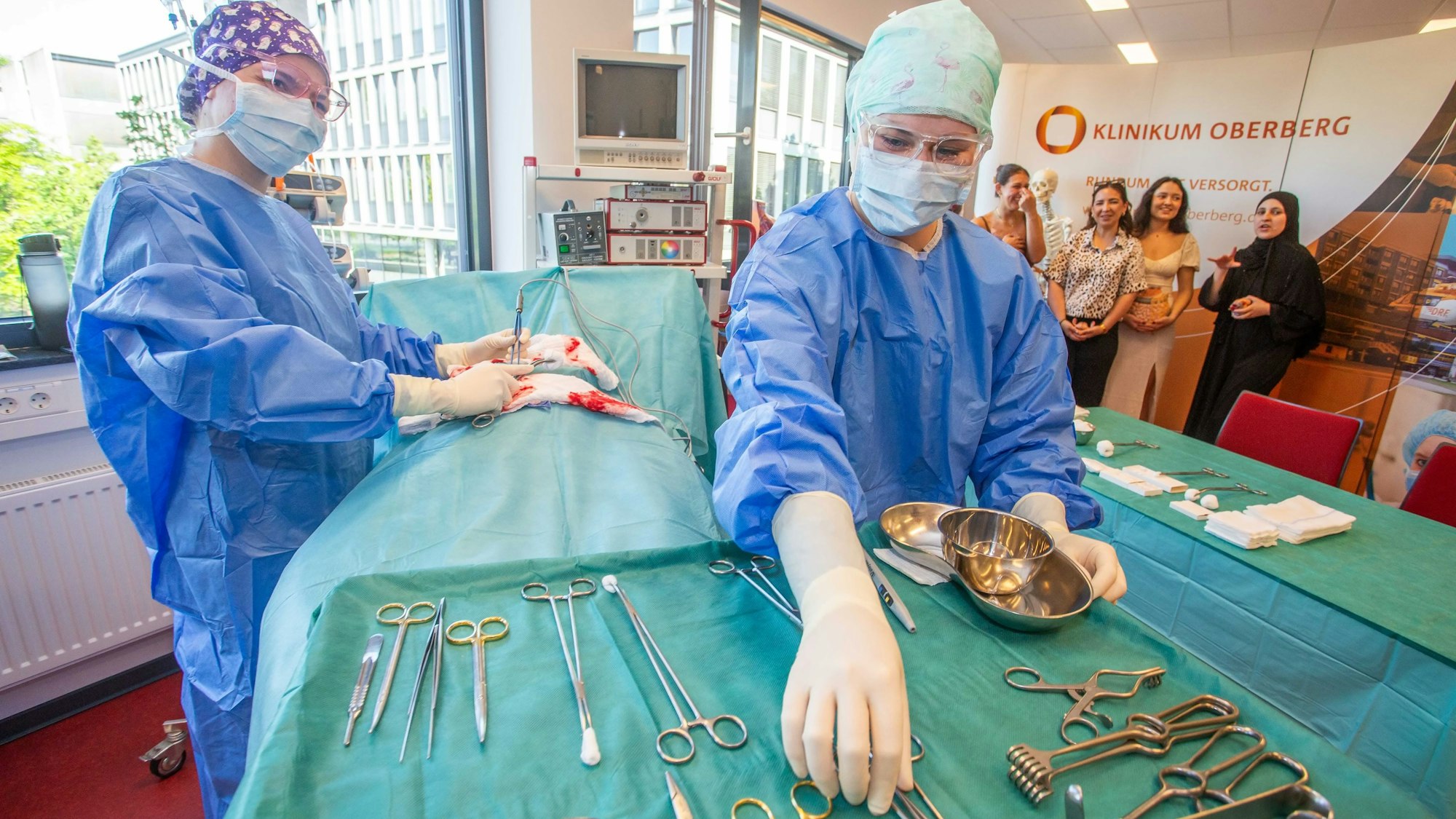 Eine Frau in steriler Schutzkleidung legt OP-Besteck auf einem Tisch zusammen.