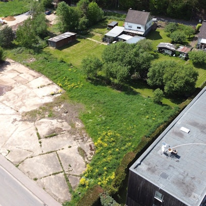 Blick von oben auf die Grundstücke, die zum Teil mit Betonplatten versiegelt sind.