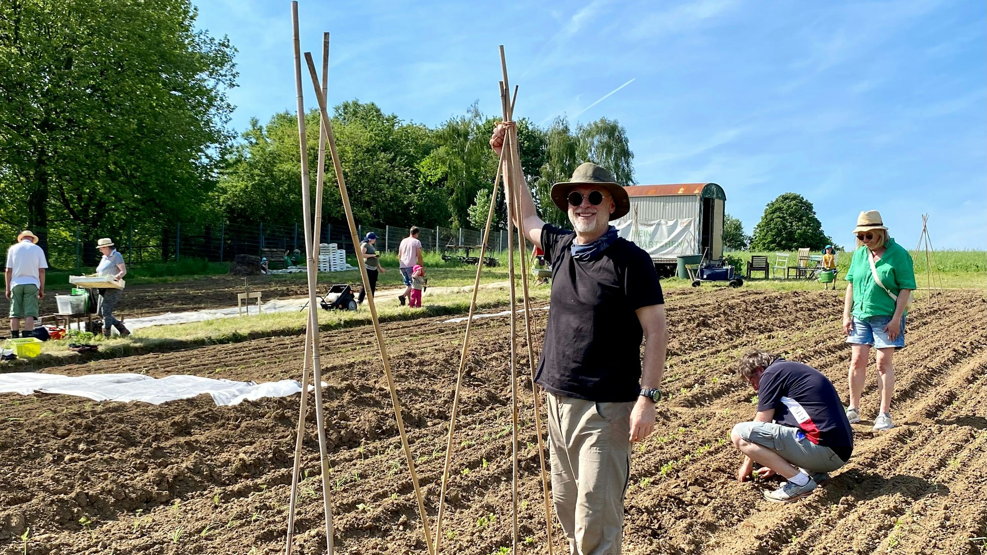 Zu sehen ist Elmar Oberdörffer, der Bambusstäbe in die Erde steckt.
