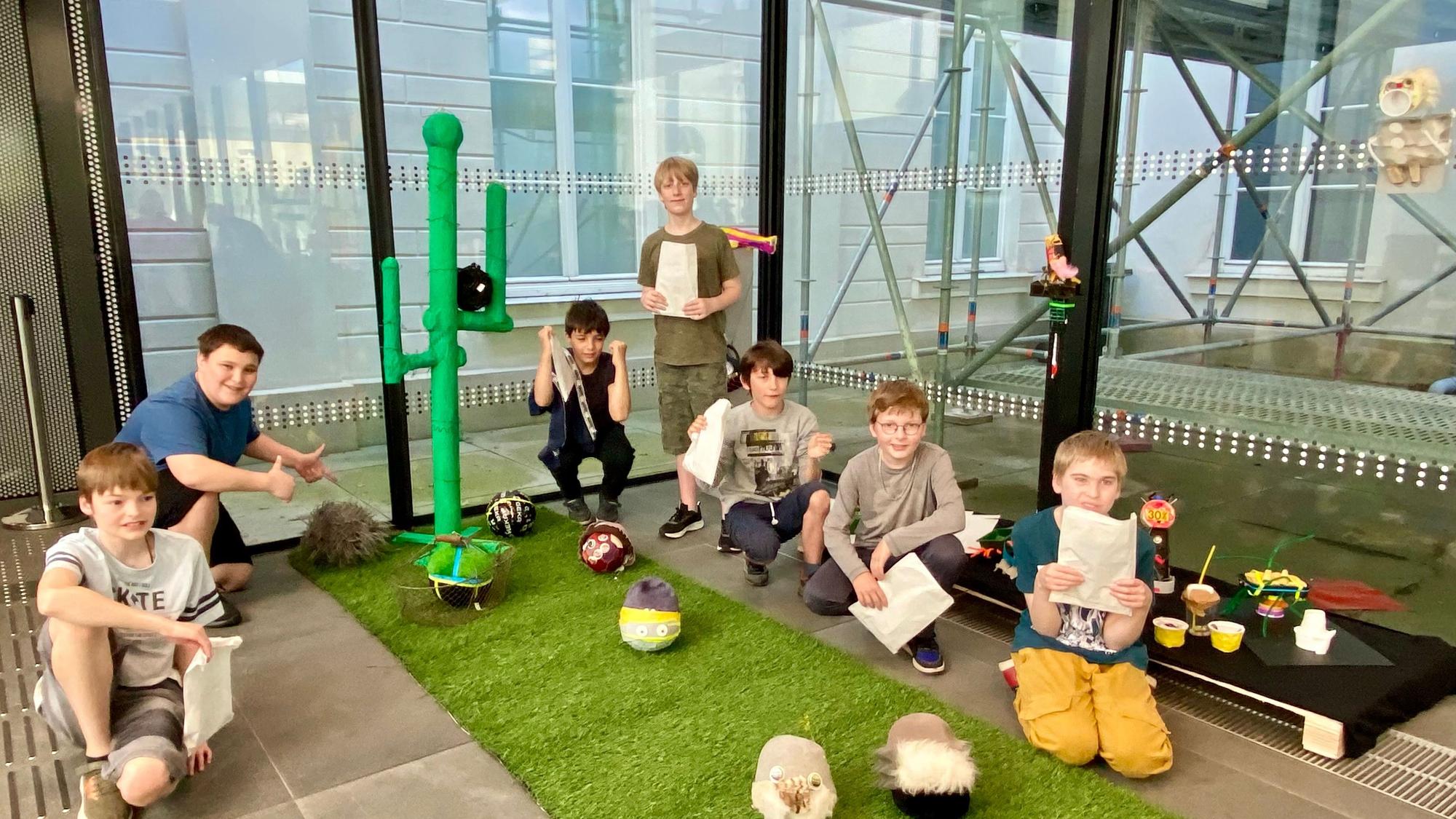 Zu sehen sind sechs Kinder, de ihre Kunstwerke zeigen.