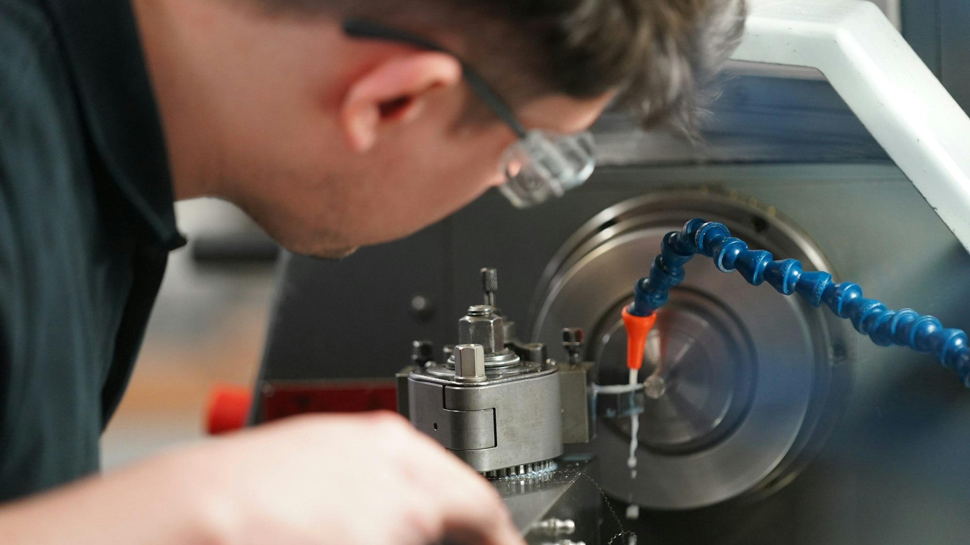 Ein Auszubildender zum Zerspanungsmechaniker arbeitet an einer Drehmaschine in der Auszubildenden-Werkstatt des Schreibgeräteherstellers Montblanc.