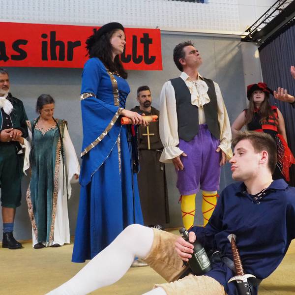 Jonas Kuley sitzt im Vordergrund, dahinter agieren mehrere Schauspieler.