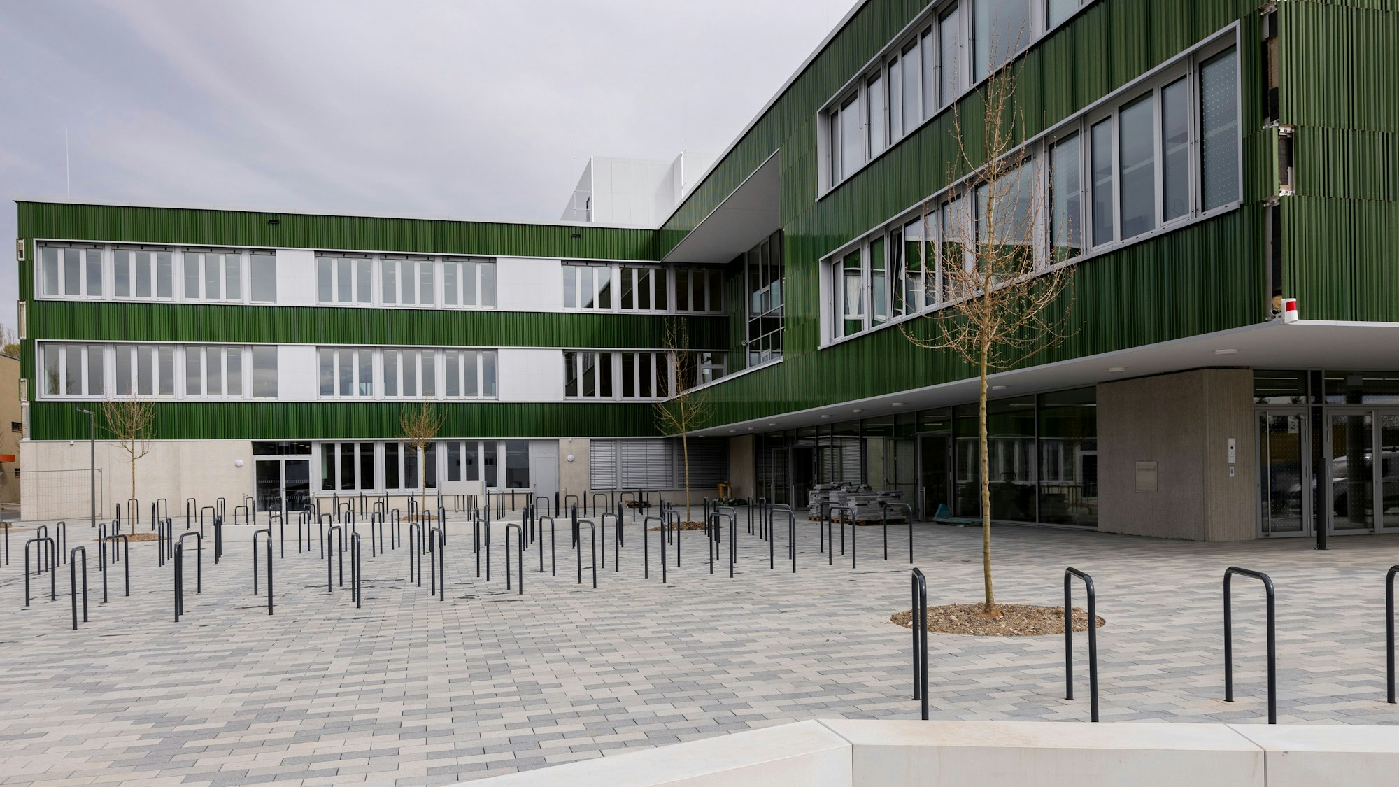 Vorplatz und Schulhof vor der Schule mit Fahrradständern.