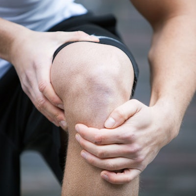 Ein Sportler hält sich das Knie