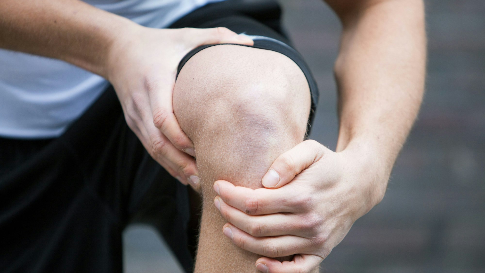 Ein Sportler hält sich das Knie