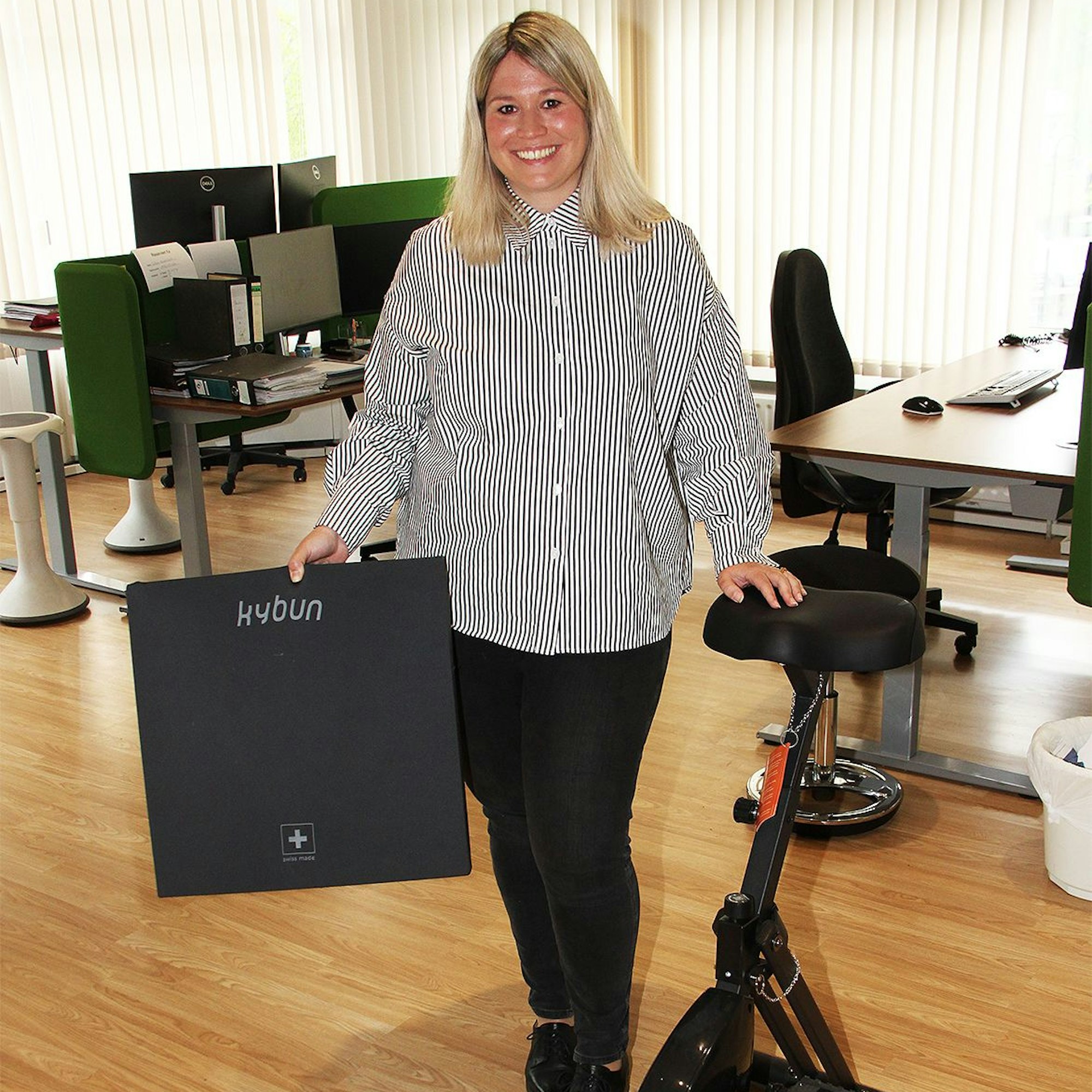 Bürgermeisterin Jennifer Meuren steht mit einer Fitnessmatte neben einem Pedaltreter.