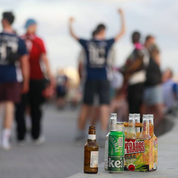 Auf einer Balustrade stehen mehrere leere Flachen alkoholischer Getränke.