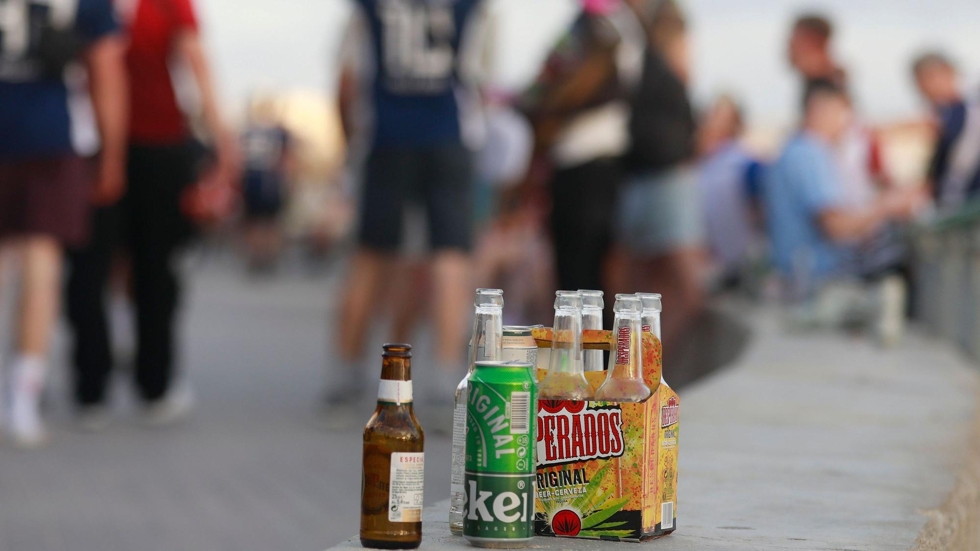 Auf einer Balustrade stehen mehrere leere Flachen alkoholischer Getränke.