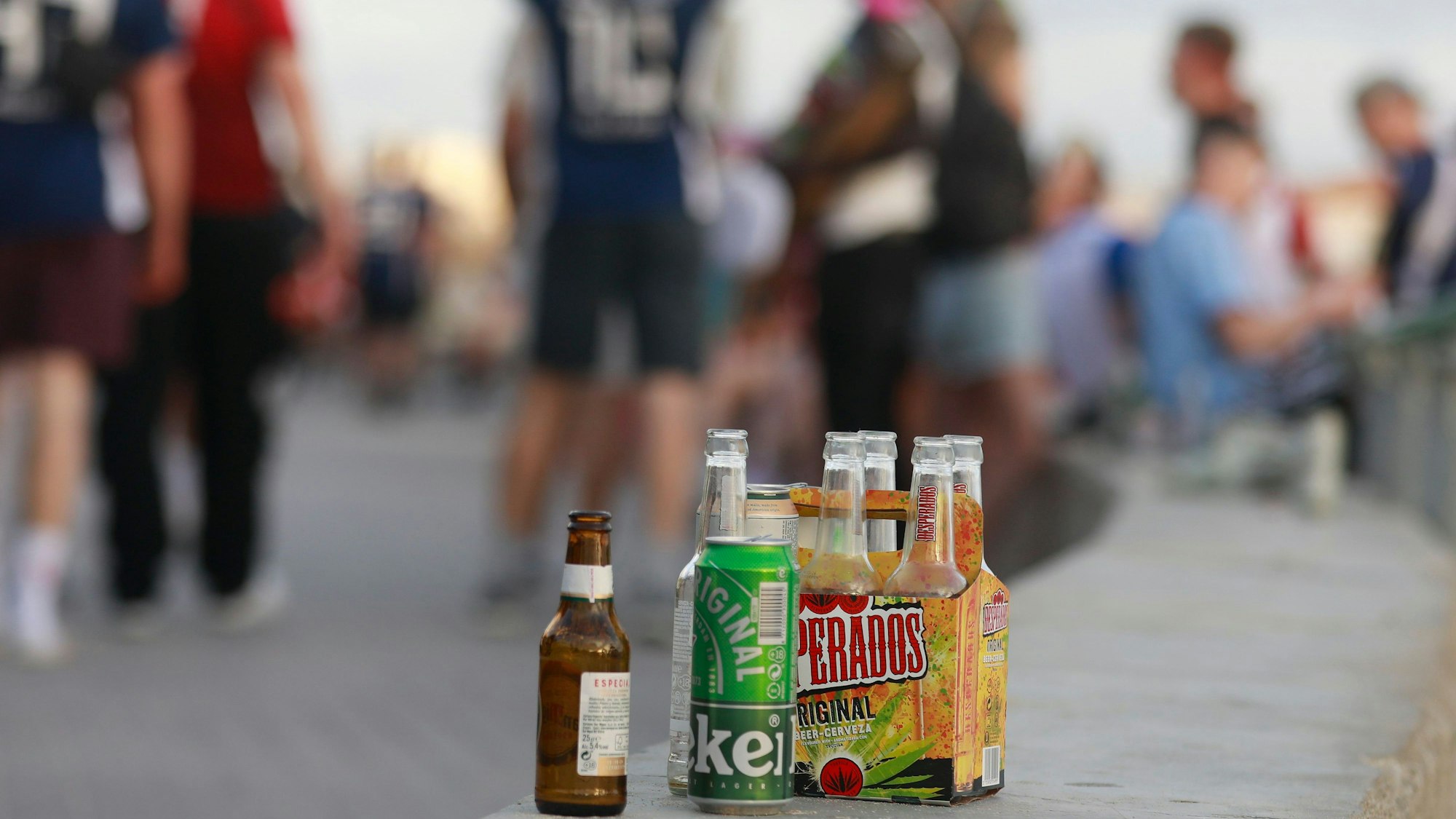Auf einer Balustrade stehen mehrere leere Flachen alkoholischer Getränke.
