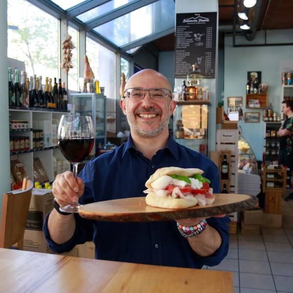 Panino vom Feinsten serviert mit einem Glas Rotwein.