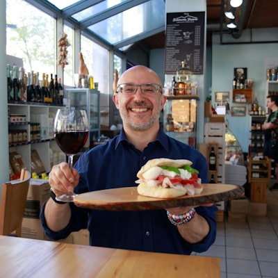Panino vom Feinsten serviert mit einem Glas Rotwein.