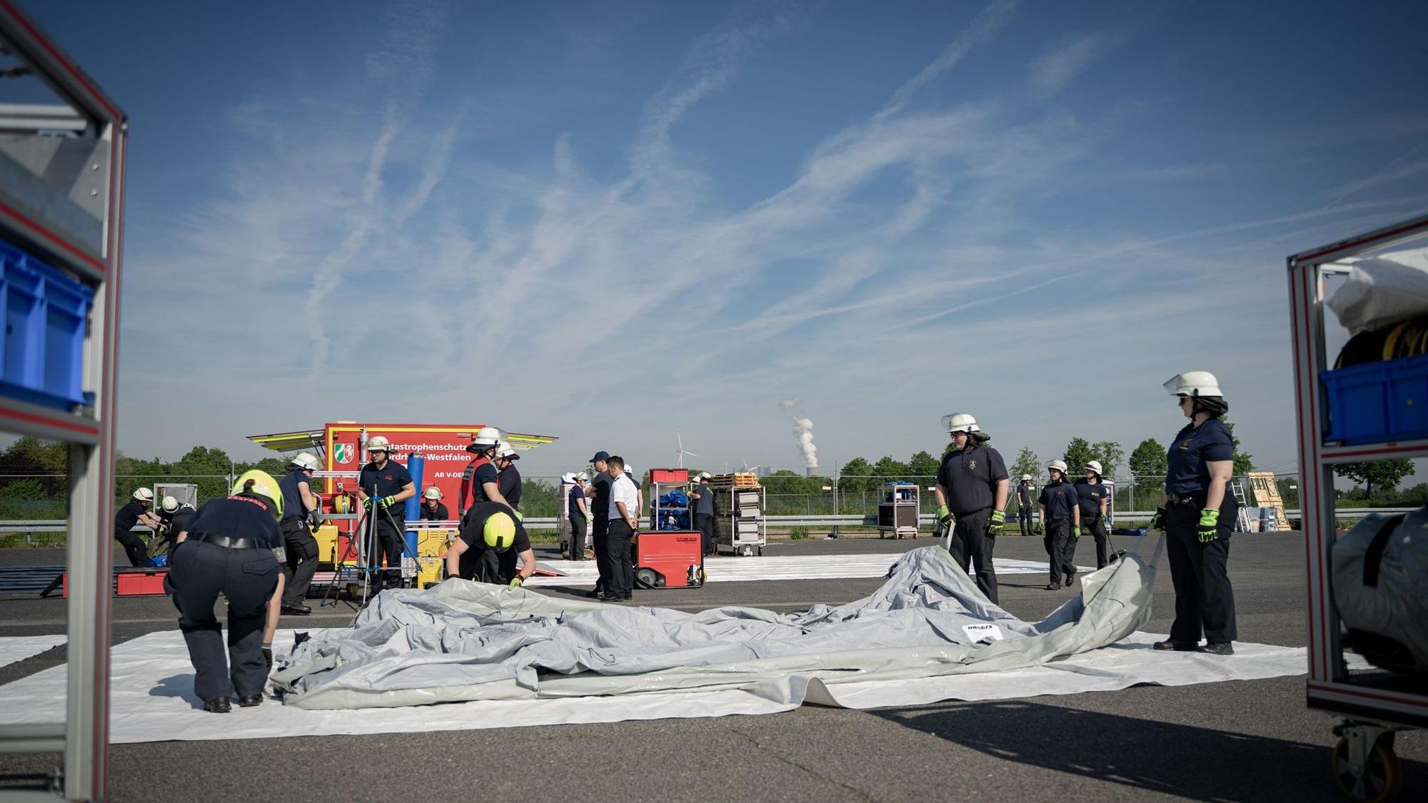 Feuerwehrleute bauen den Dekontaminationsplatz auf.