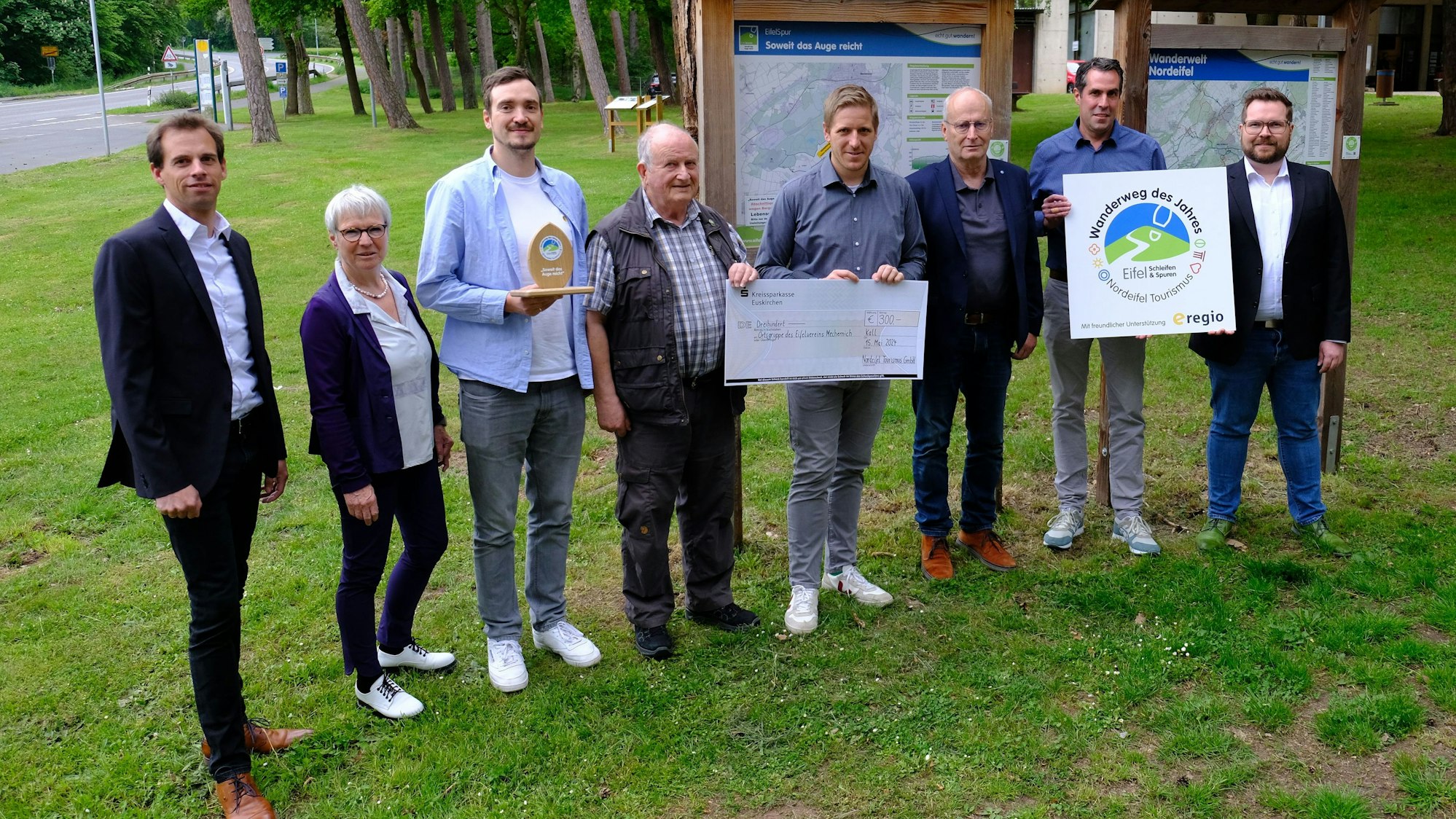 Die Gruppenaufnahme zeigt die Akteure der Preisverleihung, darunter Landrat Markus Ramers und Eifelvereins-Chef Horst Müller, die einen symbolischen Spendenscheck halten.