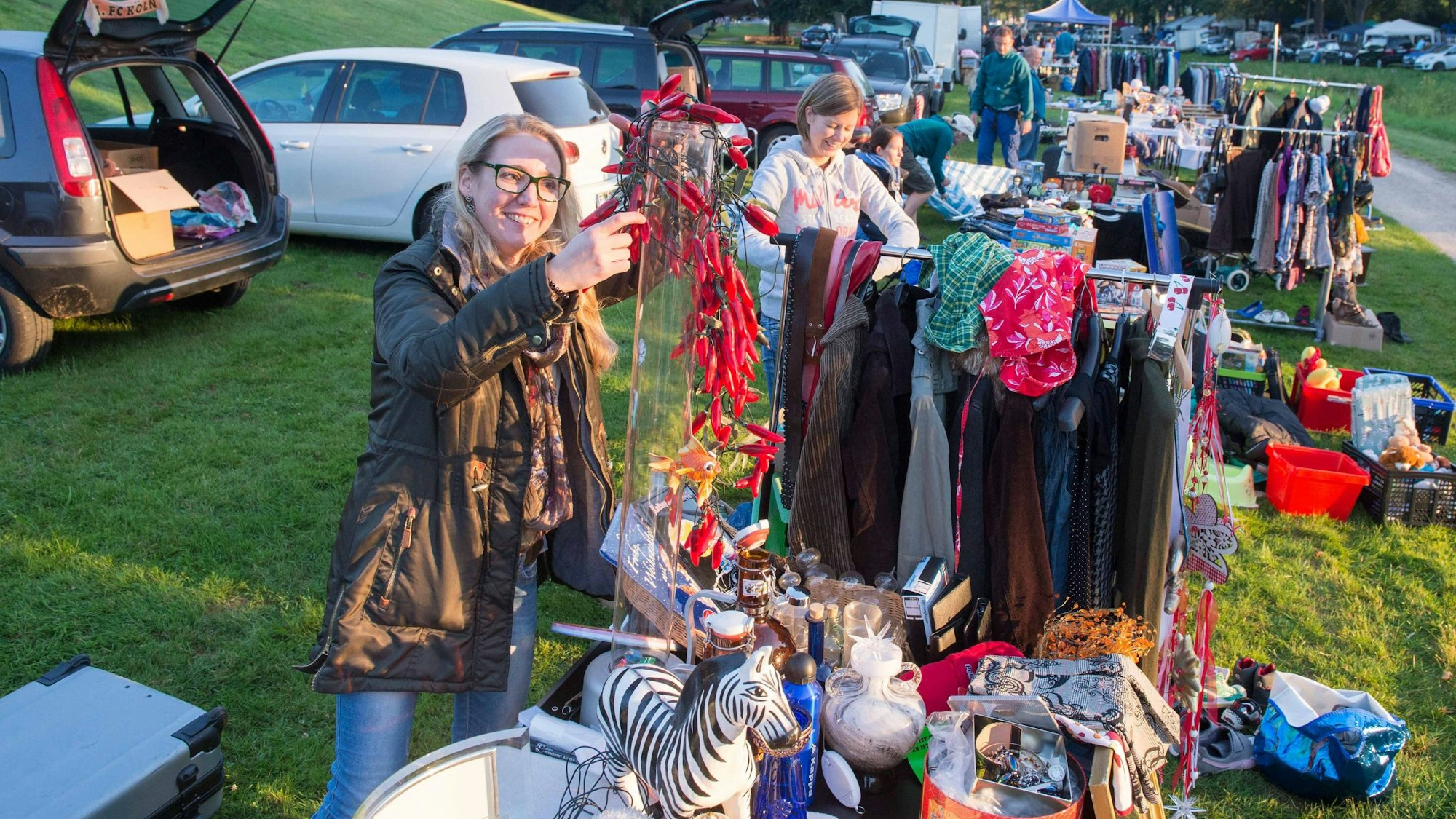 Eine Frau steht hinter einem Verkaufsstand mit Kleidung und Spielzeug.