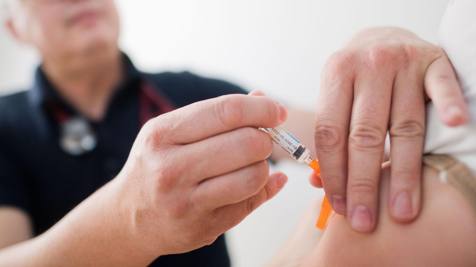 Ein Kinderarzt impft ein Kind mit einem 6-fach-Kombinationsimpfstoff gegen Diphtherie, Tetanus (Wundstarrkrampf), Kinderlähmung (Polio), Keuchhusten (Pertussis), Haemophilus influenzae Typ b (Hib) und Hepatitis B. Die Zahl der Keuchhusten-Fälle steigt 2024.
