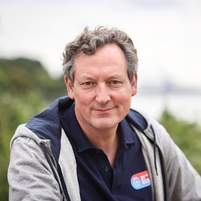 Eckart von Hirschhausen sitzt im Grünen.