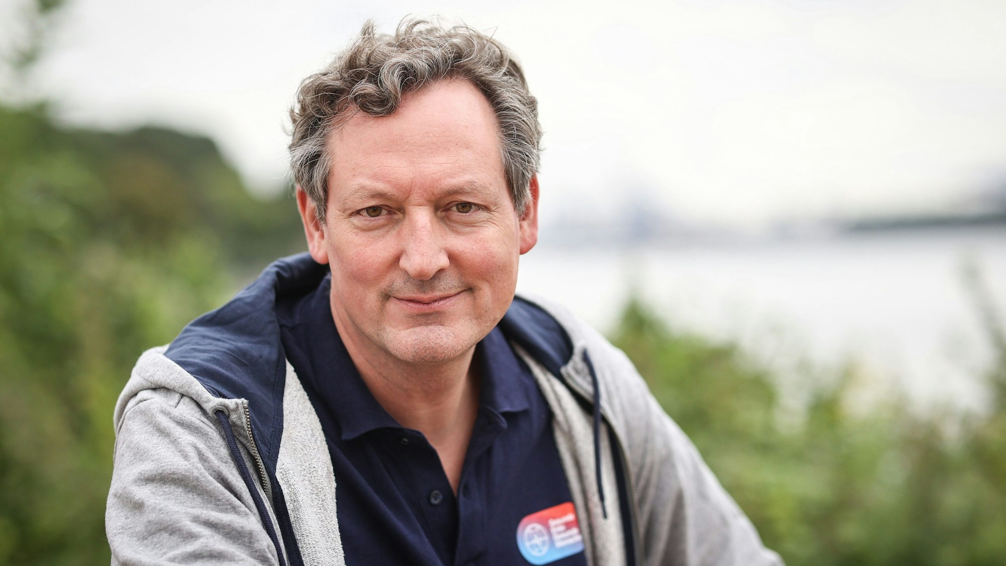 Eckart von Hirschhausen sitzt im Grünen.