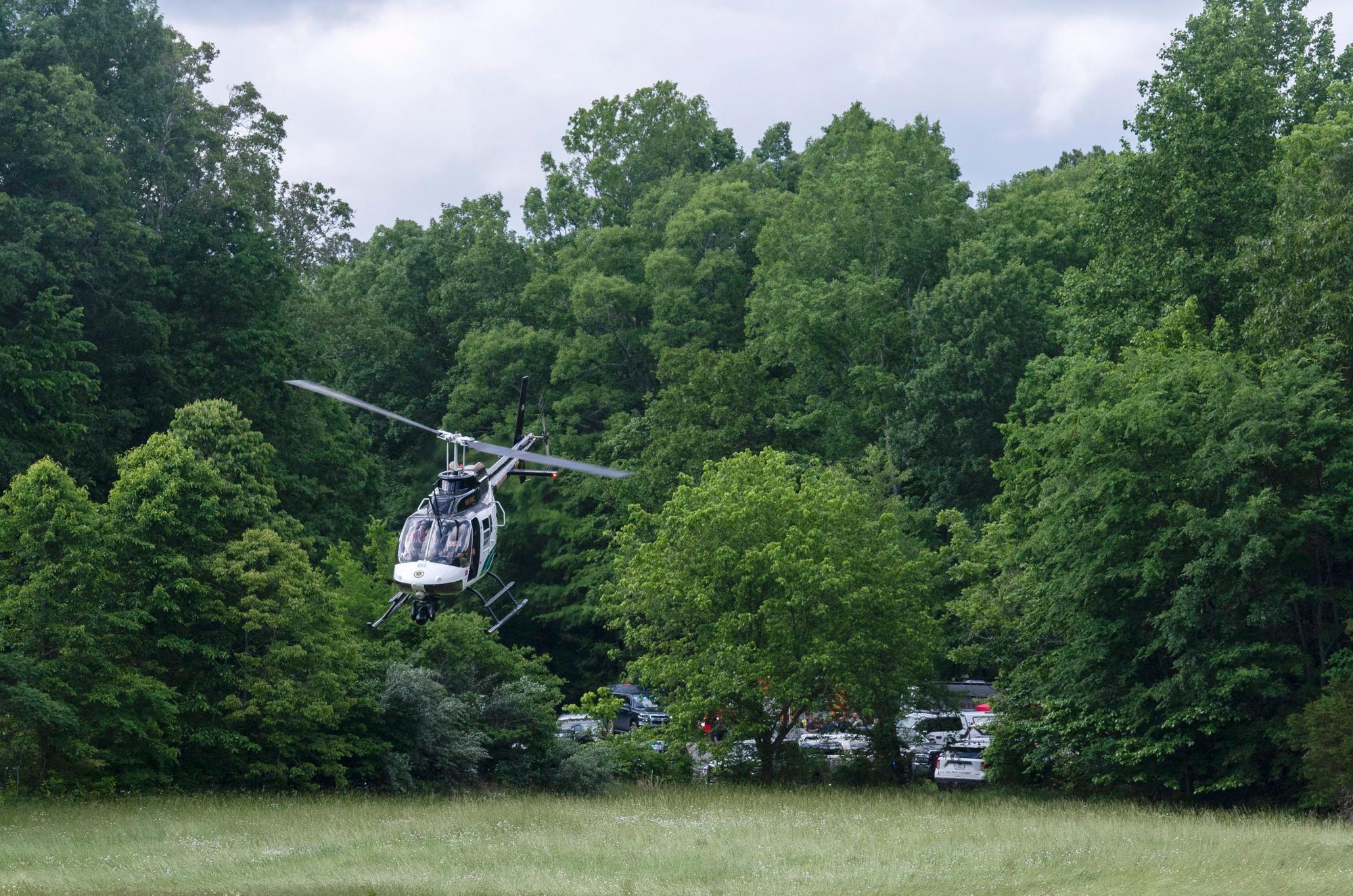 Ein Hubschrauber fliegt in der Nähe der Absturzstelle eines Flugzeugs, wo drei Menschen ums Leben kamen.