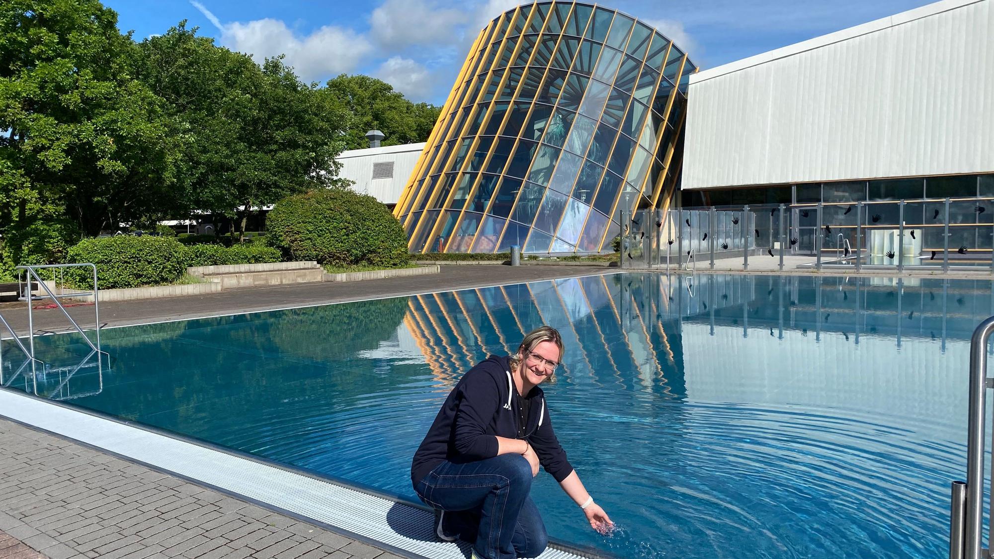 Julia Pfeiffer vor dem Schwimmerbecken im Hallenfreizeitbad. Sie fühlt, wie warm das Wasser gerade ist.