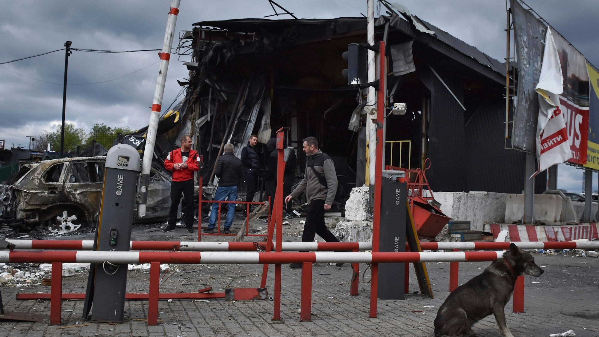 Menschen stehen in der ukrainischen Stadt Dnipro neben Gebäuden, die bei einem russischen Angriff beschädigt wurden.