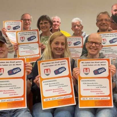 Aktive des Netzwerks „Niederkassel für Demokratie“ präsentieren Plakatentwürfe, mit denen sich interessierte Niederkasselerinnen und Niederkasseler an eine Instagram-Aktion beteiligen können.